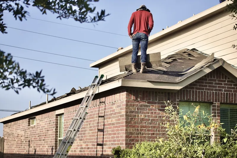 Professional roofer working on a residential roof in Great Neck Gardens